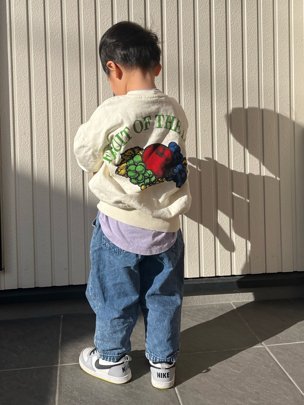 ホワイト系のスウェット、パープル系のTシャツ/カットソー、ブルー系のデニムパンツを着用したキッズの冬コーディネートの2枚目の写真