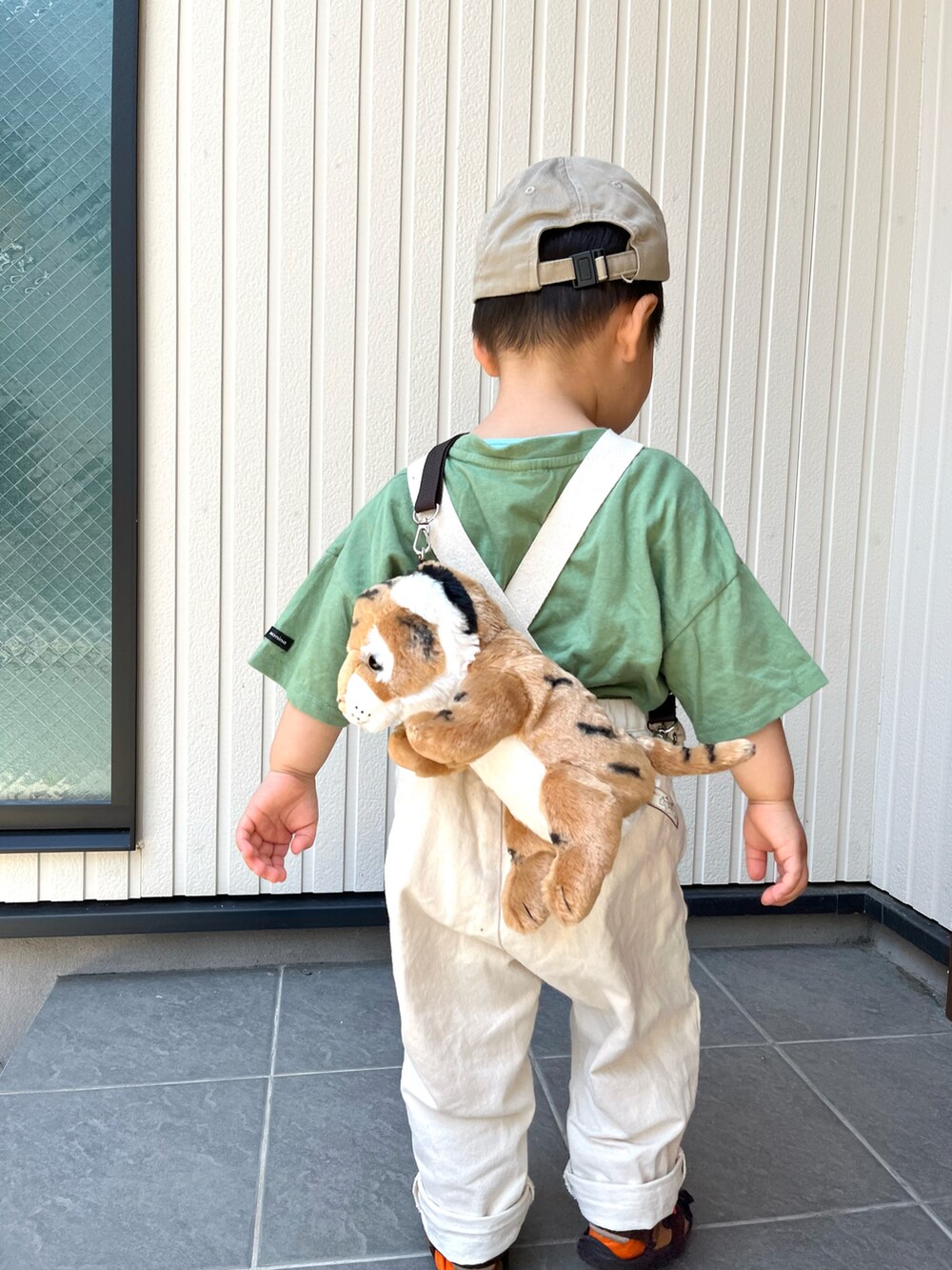 グリーン系のTシャツ/カットソー、ベージュ系のパンツ、ブラック系のスニーカーを着用したレディースの春コーディネートの3枚目の写真