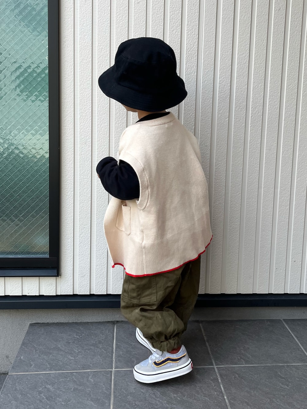 ホワイト系のベスト、ブラック系のTシャツ/カットソー、ベージュ系のワンピースを着用したレディースの冬コーディネートの4枚目の写真