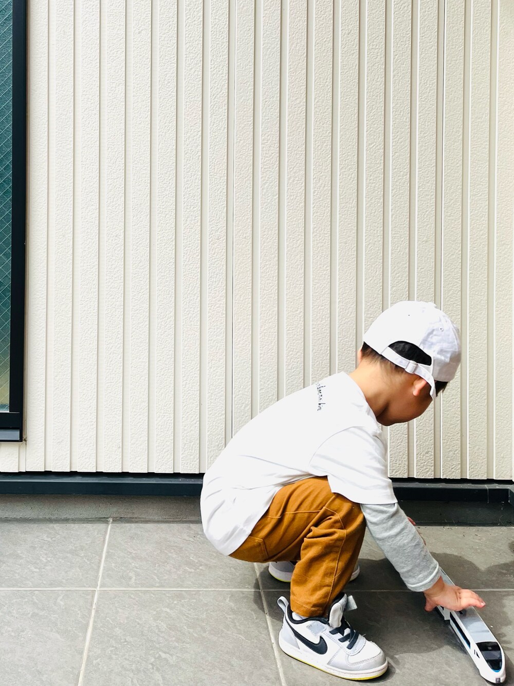 ホワイト系のTシャツ/カットソー、ブラウン系のその他パンツ、グレー系のスニーカーを着用したキッズの春コーディネートの3枚目の写真