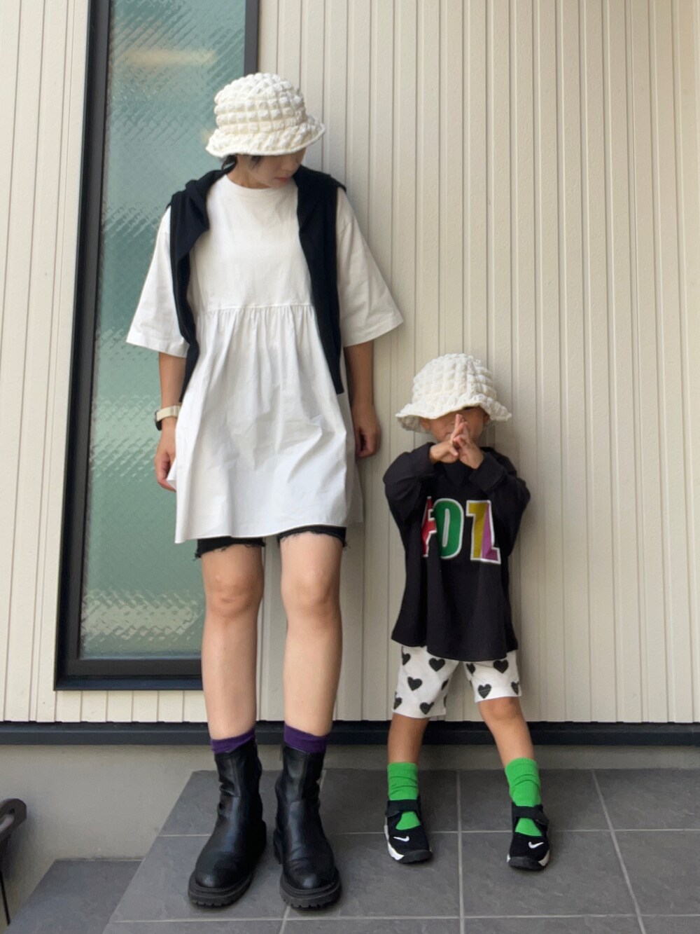 ブラック系のカーディガン/ボレロ、ホワイト系のTシャツ/カットソー、ブラック系のブーツを着用したレディースの秋コーディネートの2枚目の写真