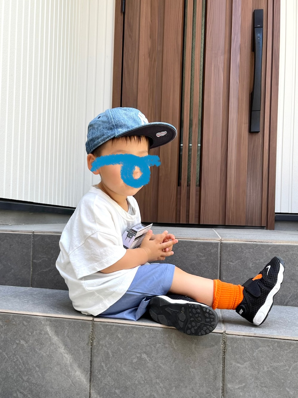 ホワイト系のスウェット、ブルー系のデニムパンツ、ブラウン系のサンダルを着用したレディースの夏コーディネートの2枚目の写真