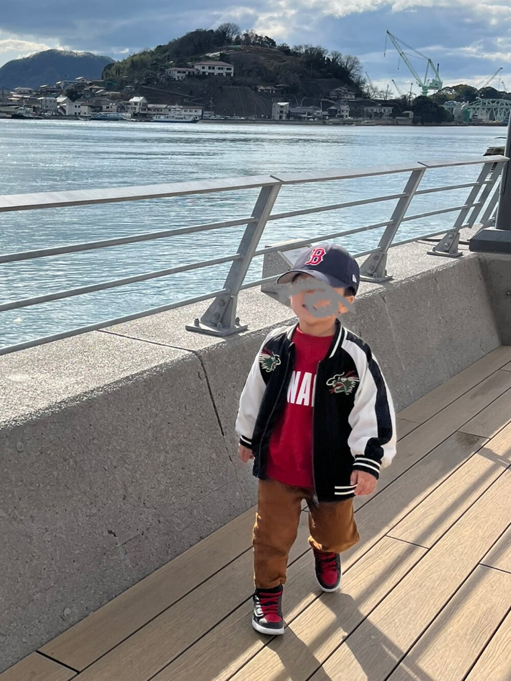 レッド系のスウェット、ブラック系のスカジャン、ブラウン系のその他パンツを着用したキッズの冬コーディネートの2枚目の写真