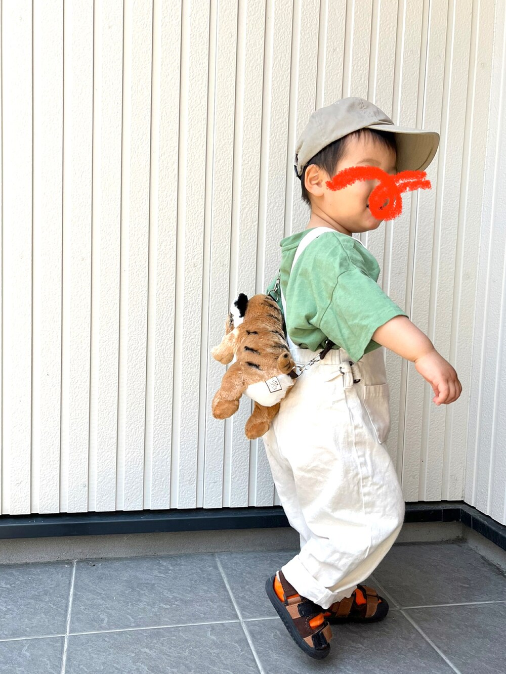 グリーン系のTシャツ/カットソー、ベージュ系のパンツ、ブラック系のスニーカーを着用したレディースの春コーディネートの2枚目の写真