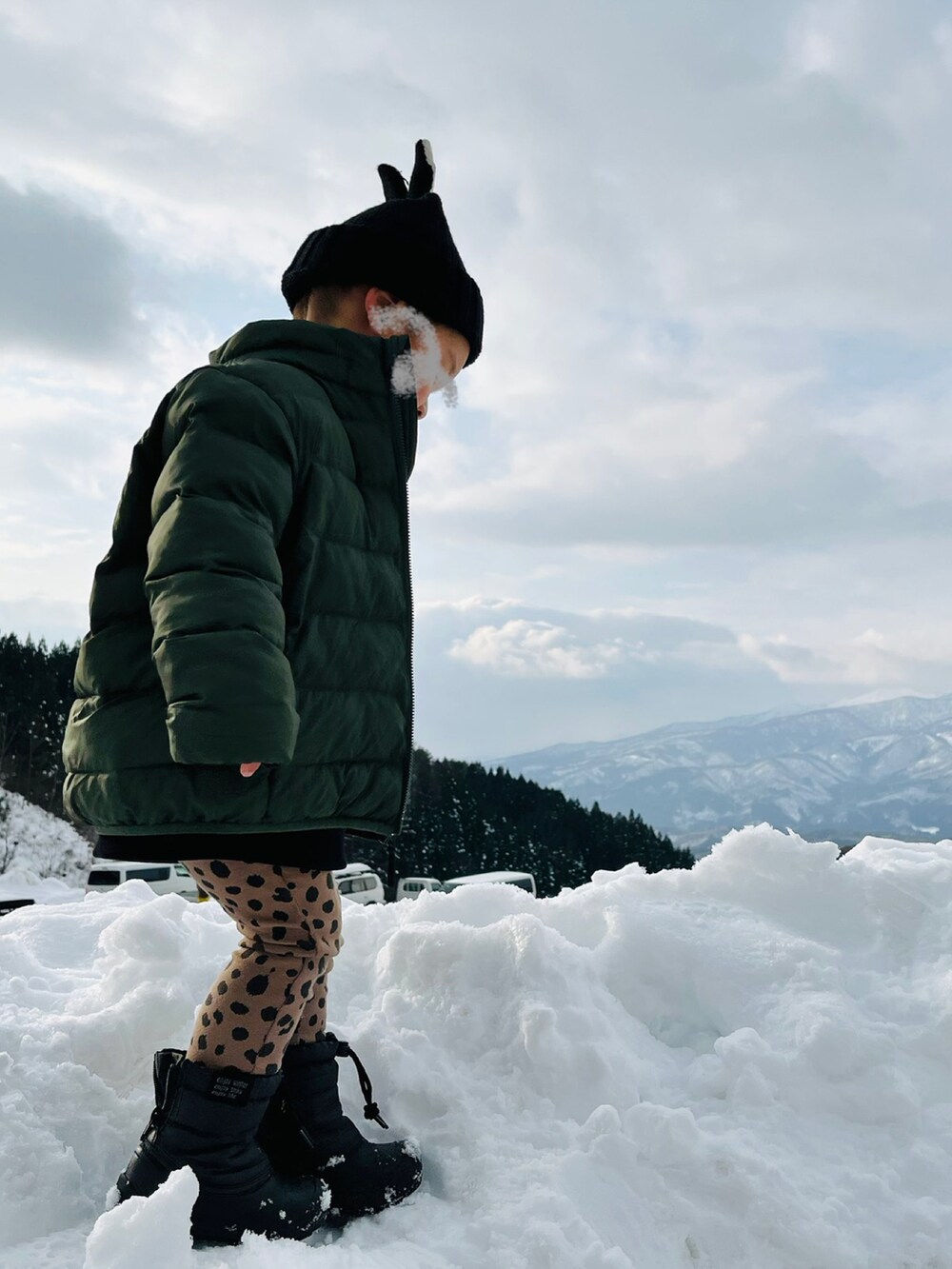 グリーン系のダウンジャケット/コート、ブラック系のスウェット、ブラック系のニットキャップ/ビーニーを着用したキッズの冬コーディネートの2枚目の写真