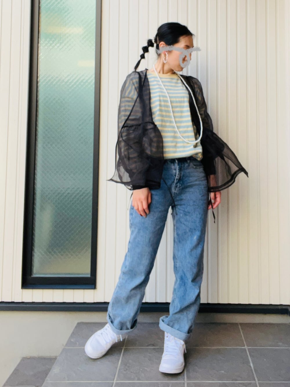 ブラック系のシャツ/ブラウス、ブルー系のデニムパンツ、ホワイト系のスニーカーを着用したレディースの春コーディネートの2枚目の写真