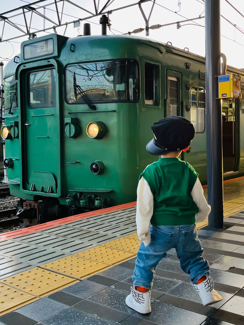 グリーン系のTシャツ/カットソー、ブルー系のデニムパンツ、ホワイト系のスニーカーを着用したキッズの春コーディネートの4枚目の写真