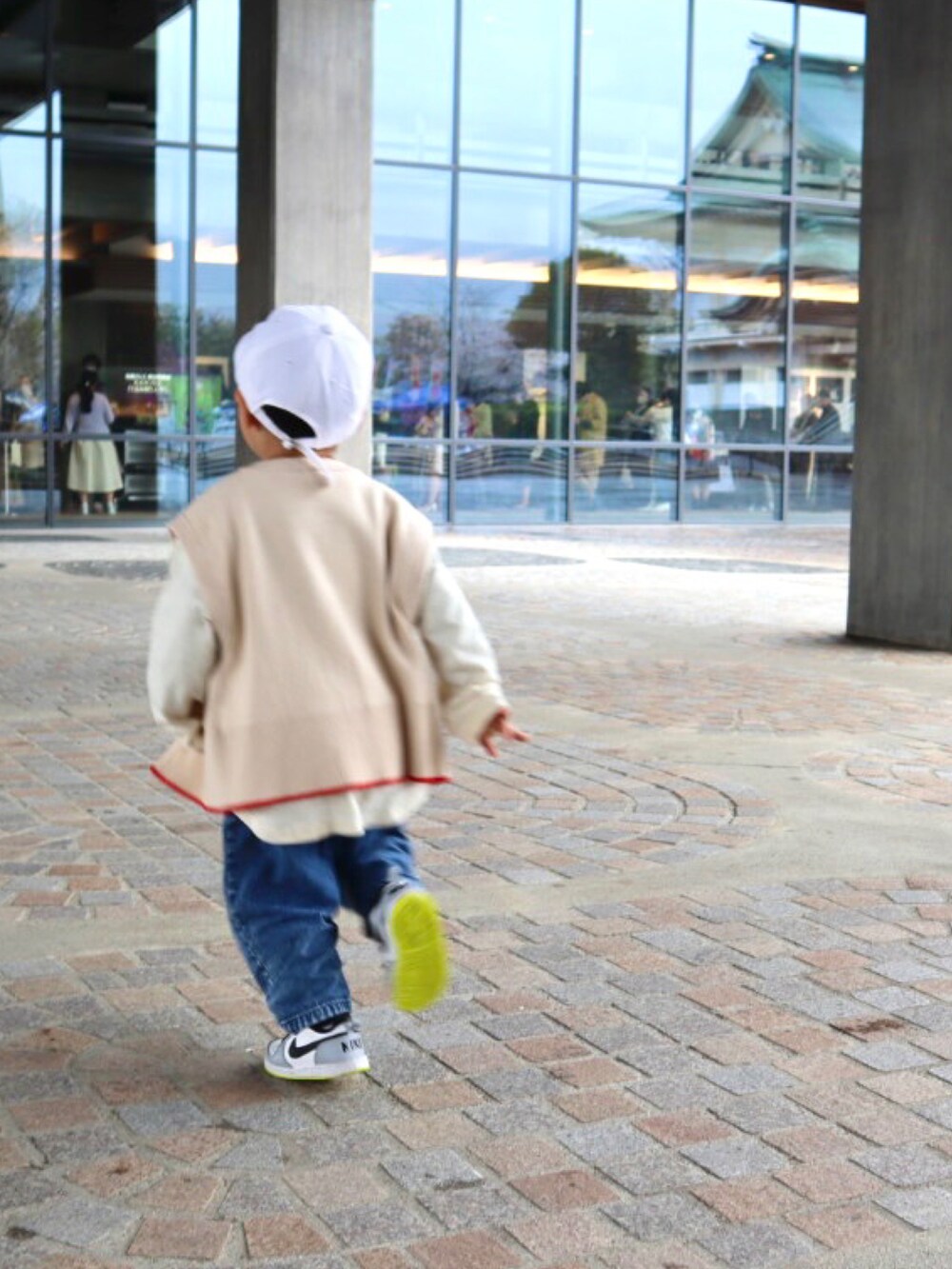 ホワイト系のベスト、ホワイト系のTシャツ/カットソー、ブルー系のデニムパンツを着用したキッズの春コーディネートの4枚目の写真