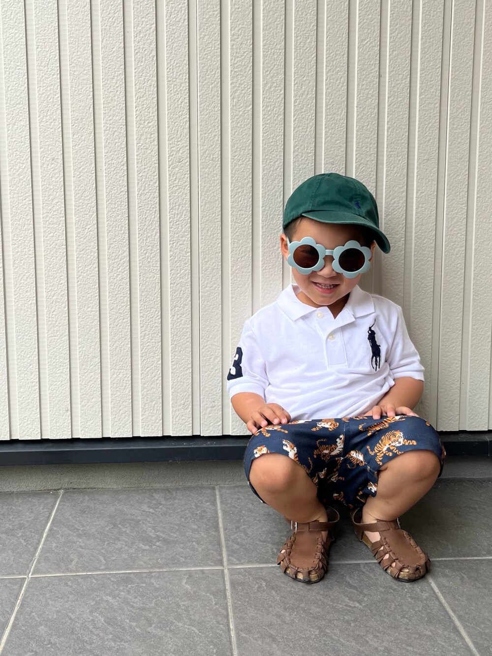 ブルー系のその他パンツ、ホワイト系のポロシャツ、ブラウン系のサンダルを着用したキッズの夏コーディネートの2枚目の写真