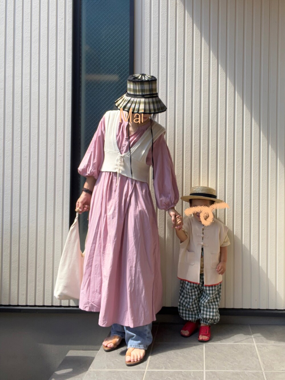 ベージュ系のベスト、ピンク系のシャツワンピース、ブルー系のデニムパンツを着用したレディースの秋コーディネートの2枚目の写真