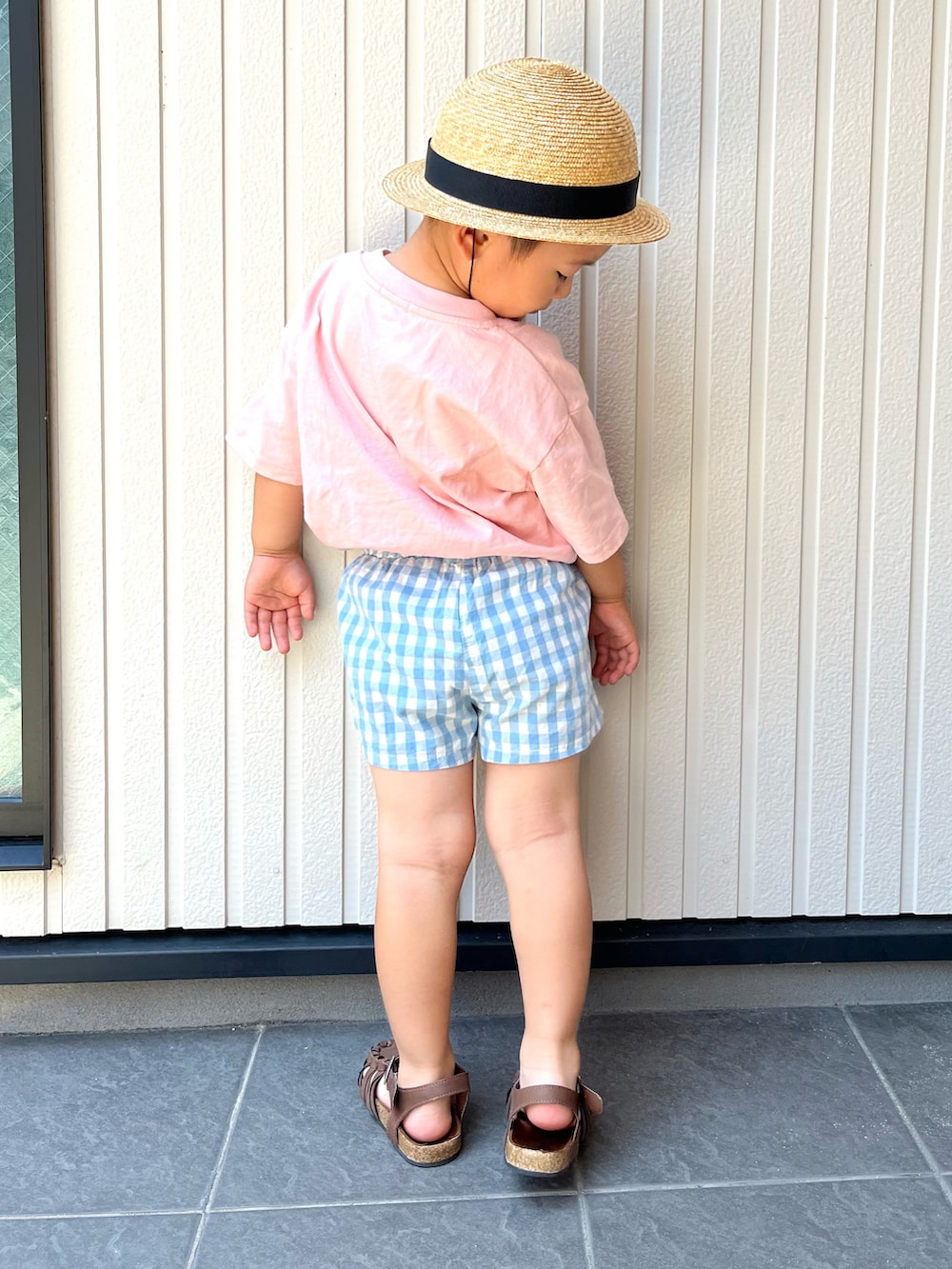 ピンク系のTシャツ/カットソー、ブラック系のワンピース、ブラウン系のサンダルを着用したレディースの夏コーディネートの2枚目の写真