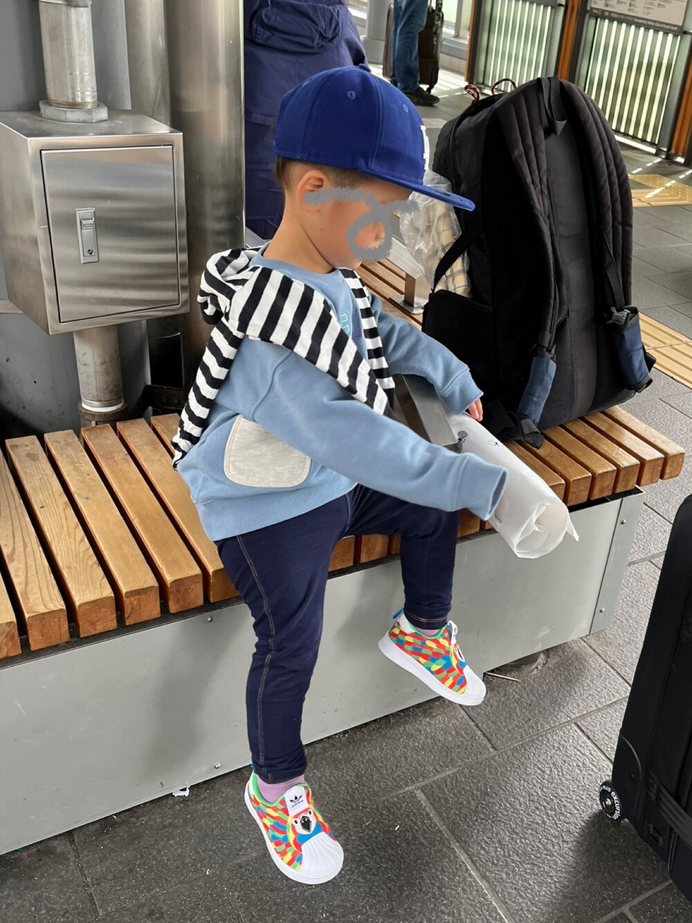 ブルー系のスウェット、パープル系のトップス、ブラック系のデニムパンツを着用したレディースの秋コーディネートの2枚目の写真