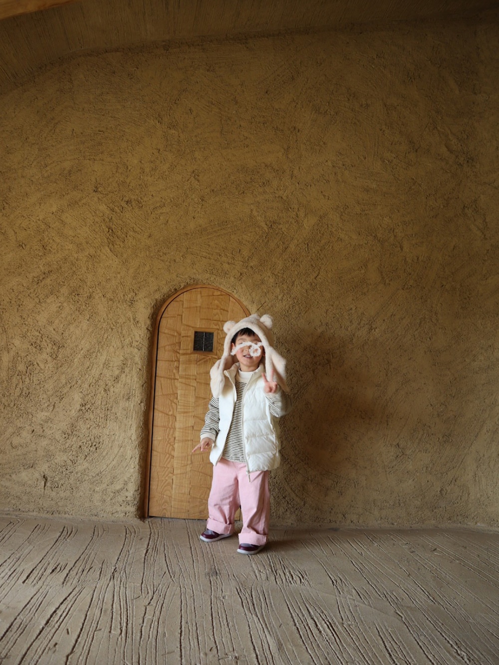 ベージュ系のワンピース、ブラウン系のブーツ、ホワイト系のTシャツ/カットソーを着用したレディースの冬コーディネートの2枚目の写真