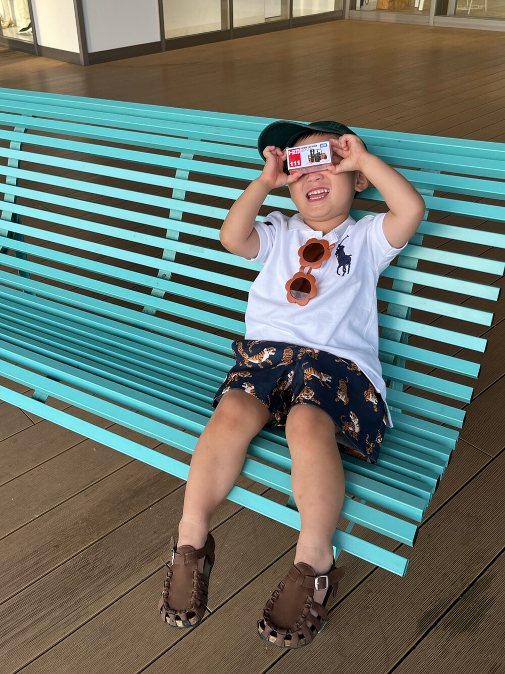 ブルー系のその他パンツ、ホワイト系のポロシャツ、ブラウン系のサンダルを着用したキッズの夏コーディネートの3枚目の写真