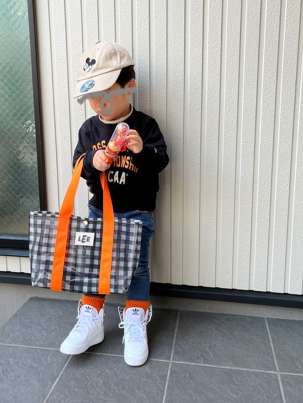 ブラック系のスウェット、ブルー系のデニムパンツ、ブラック系のトートバッグを着用したキッズの冬コーディネートの2枚目の写真