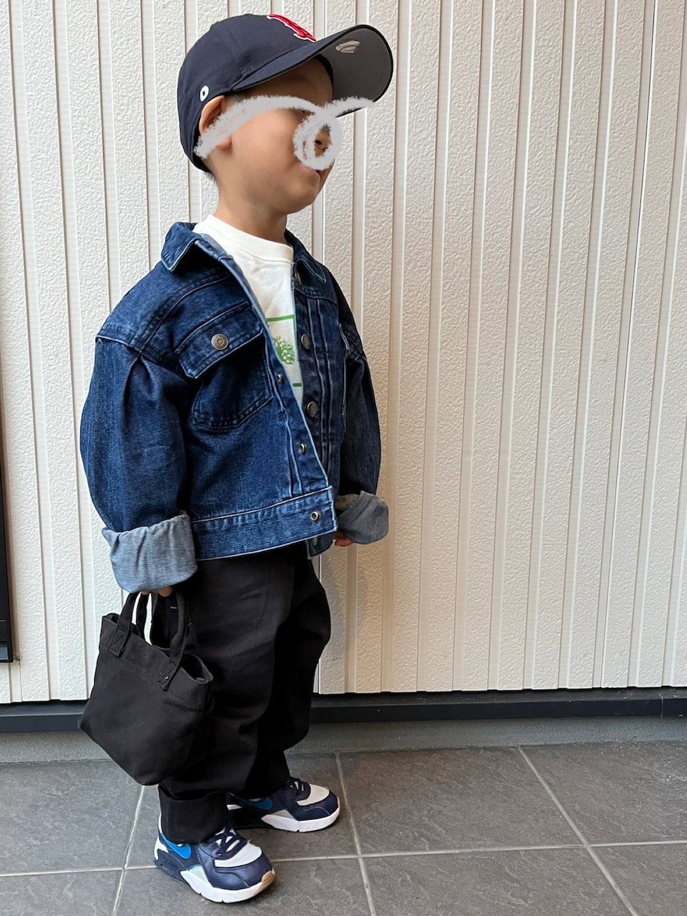 ブラック系のスカート、ブラック系のデニムジャケット、ホワイト系のTシャツ/カットソーを着用したレディースの秋コーディネートの2枚目の写真