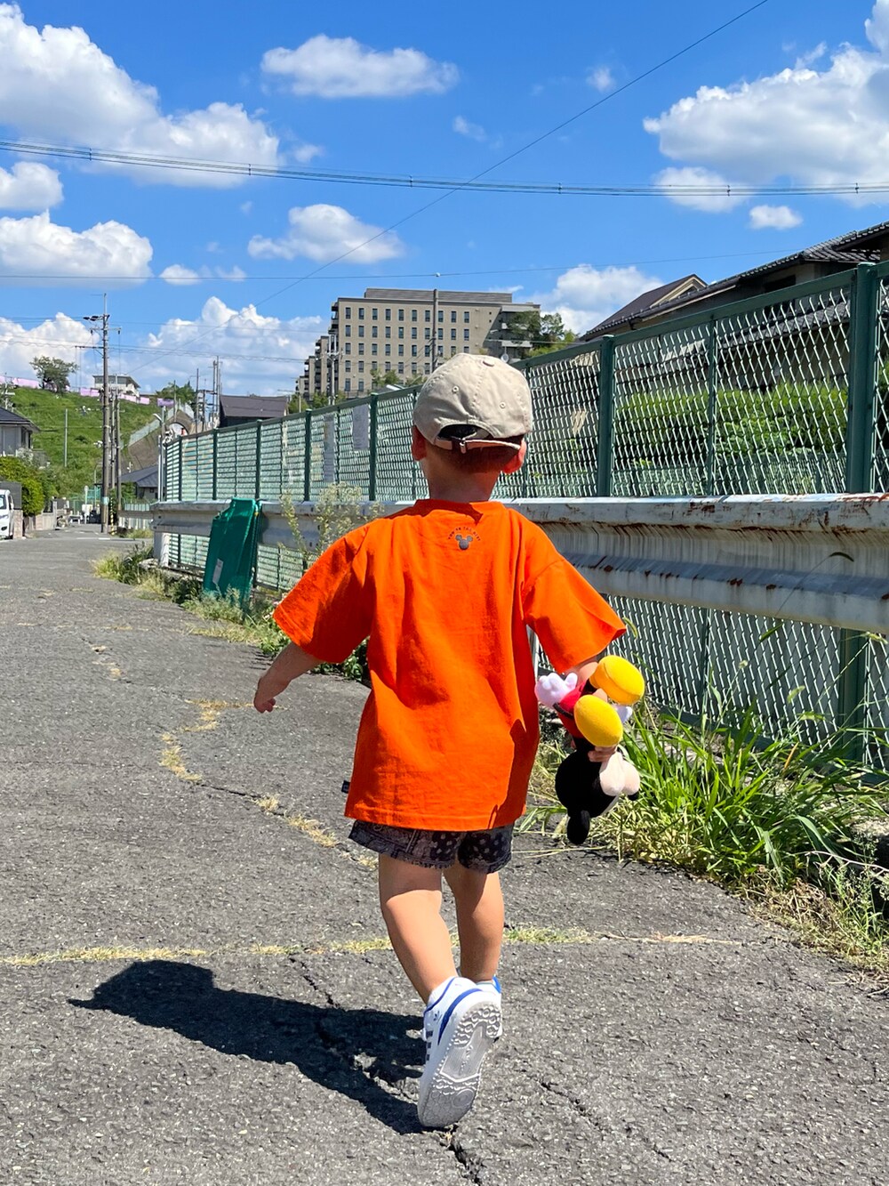 オレンジ系のTシャツ/カットソー、ブラック系のパンツ、ホワイト系のスニーカーを着用したキッズの秋コーディネートの3枚目の写真