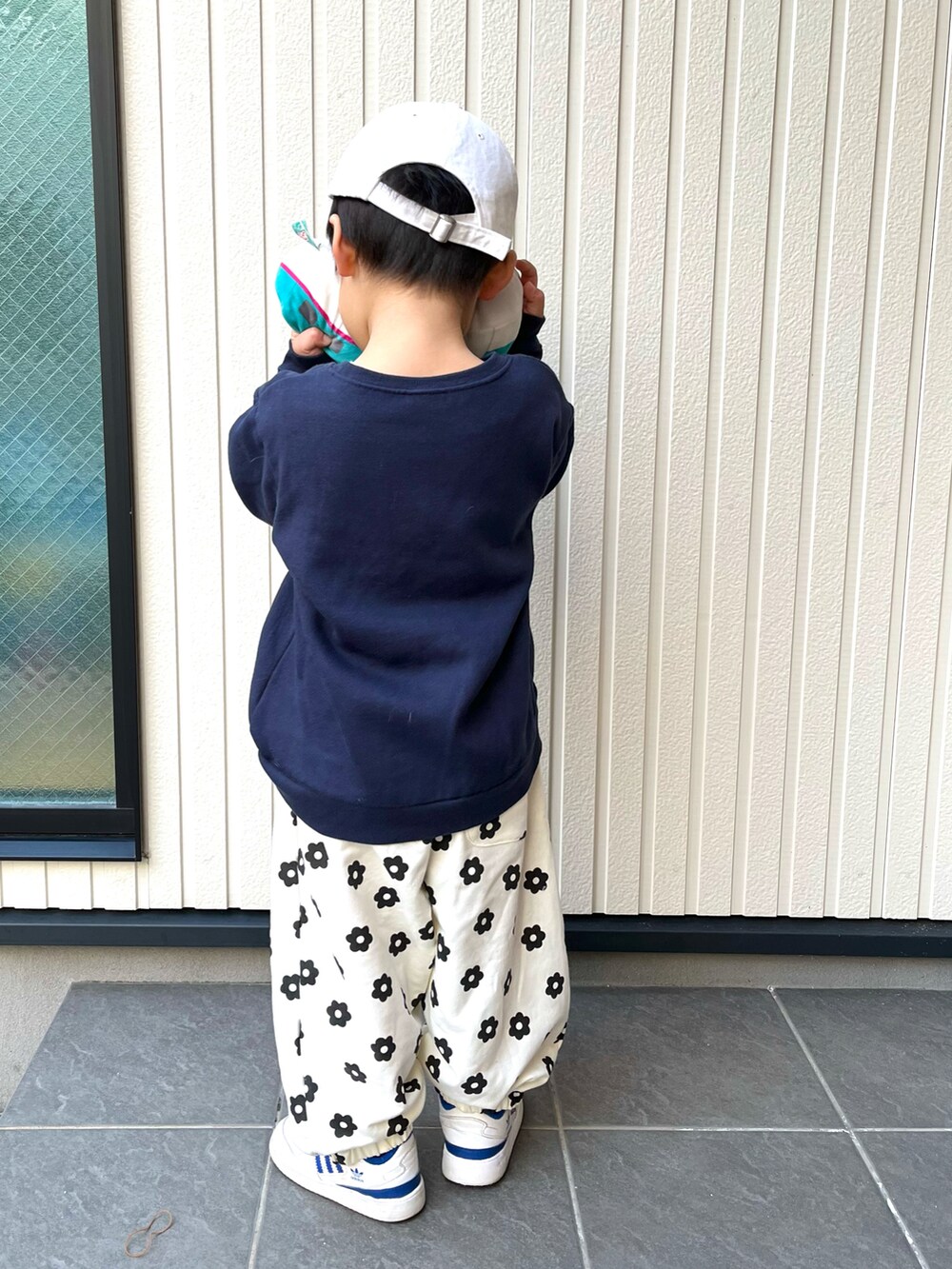 ブルー系のスウェット、ホワイト系のスウェットパンツ、ホワイト系のスニーカーを着用したキッズの冬コーディネートの2枚目の写真