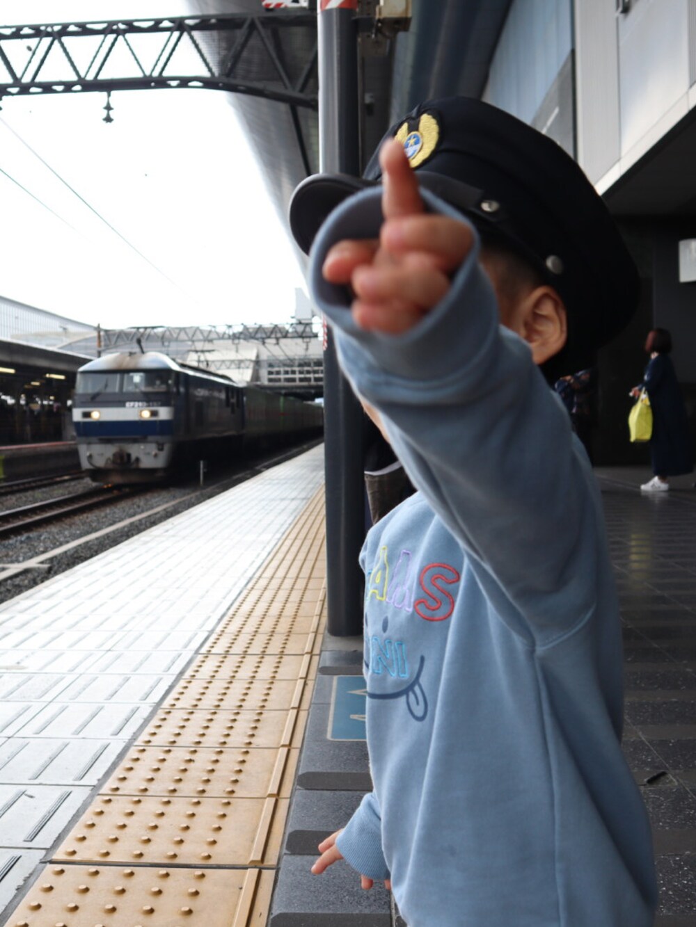 ブルー系のスウェット、パープル系のトップス、ブラック系のデニムパンツを着用したレディースの秋コーディネートの3枚目の写真