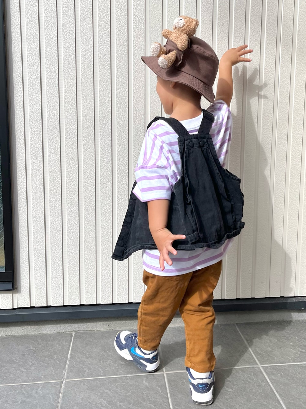 パープル系のTシャツ/カットソー、ブラック系のベスト、ブラウン系のその他パンツを着用したキッズの秋コーディネートの2枚目の写真