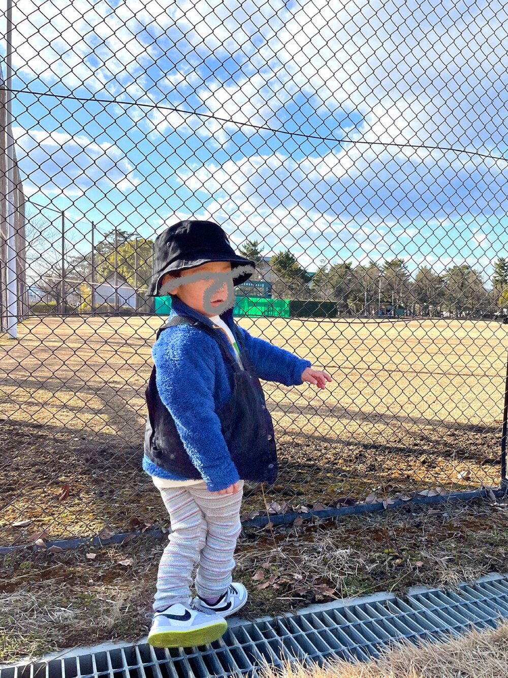 ブラック系のベスト、ホワイト系のベスト、グリーン系のモッズコートを着用したレディースの冬コーディネートの2枚目の写真