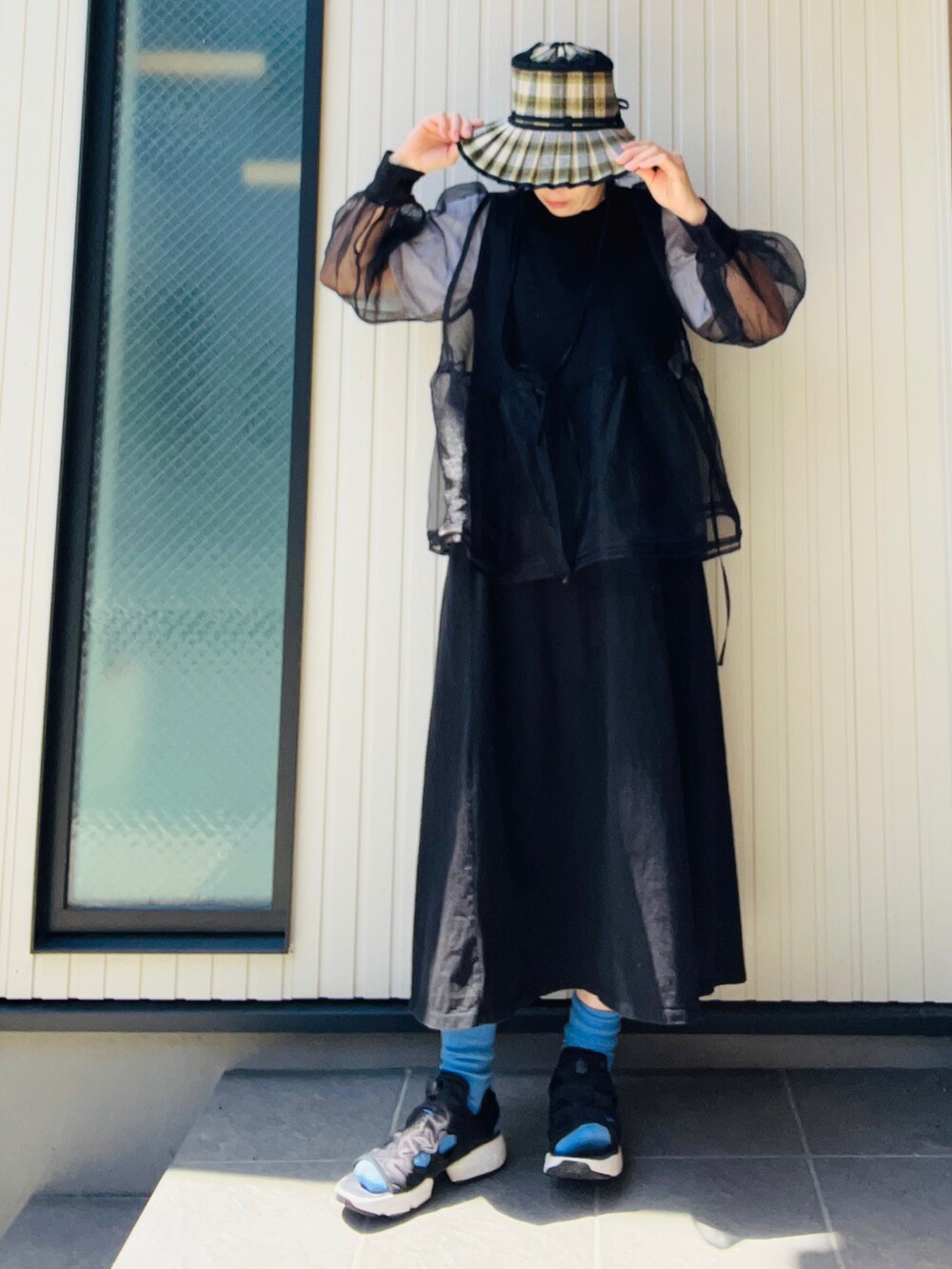 ブラック系のシャツ/ブラウス、ブラック系のワンピース、ブラック系のスニーカーを着用したレディースの春コーディネートの2枚目の写真