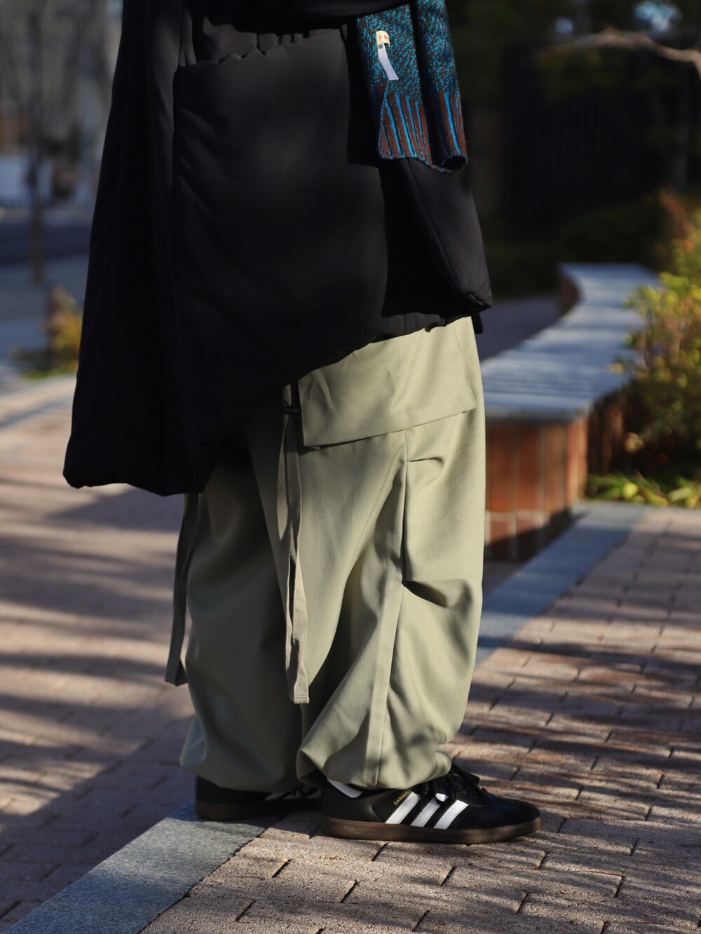 ブラック系のダウンジャケット/コート、グリーン系のカーゴパンツ、ブラック系のスニーカーを着用したメンズの冬コーディネートの4枚目の写真