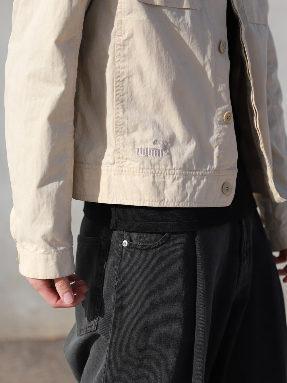 ベージュ系のミリタリージャケット、ブラック系のデニムパンツを着用したメンズの秋コーディネートの2枚目の写真