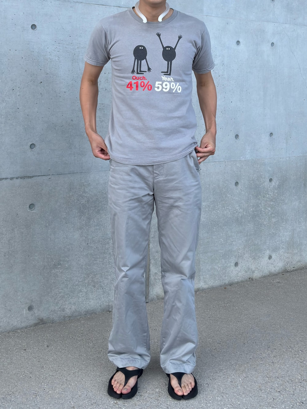 グレー系のチノパンツ、グレー系のTシャツ/カットソー、ブラック系のサンダルを着用したメンズの夏コーディネートの2枚目の写真