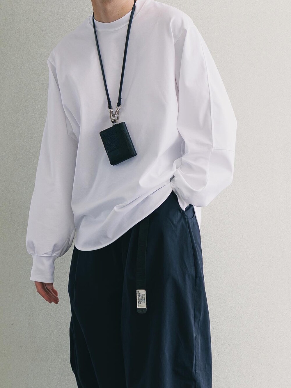 ホワイト系のTシャツ/カットソー、ブルー系のパンツ、グレー系のスニーカーを着用したメンズの秋コーディネートの3枚目の写真