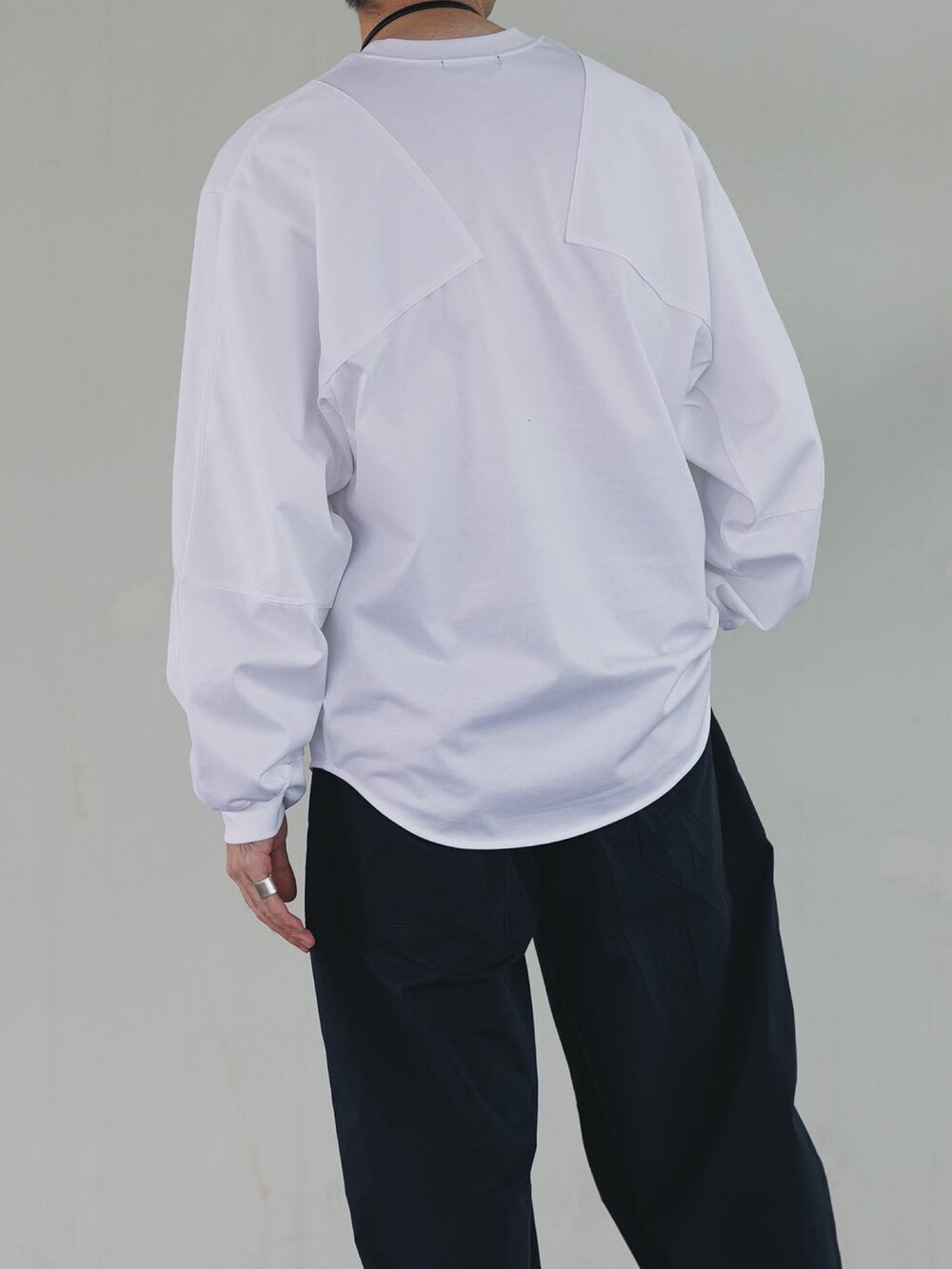 ホワイト系のTシャツ/カットソー、ブルー系のパンツ、グレー系のスニーカーを着用したメンズの秋コーディネートの4枚目の写真