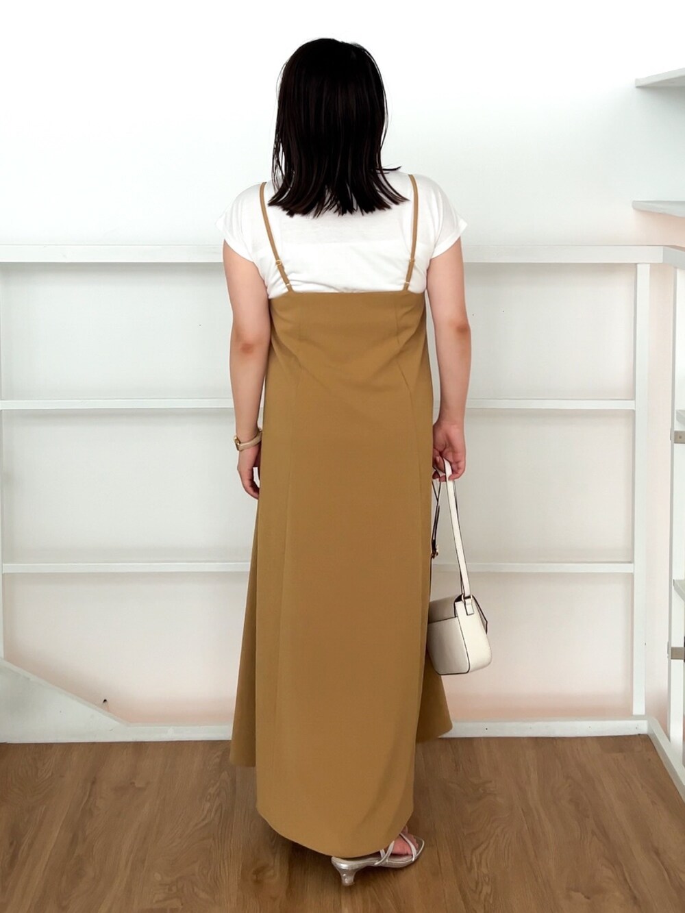 イエロー系のワンピース、ホワイト系のショルダーバッグ、シルバー系のサンダルを着用したレディースの夏コーディネートの5枚目の写真