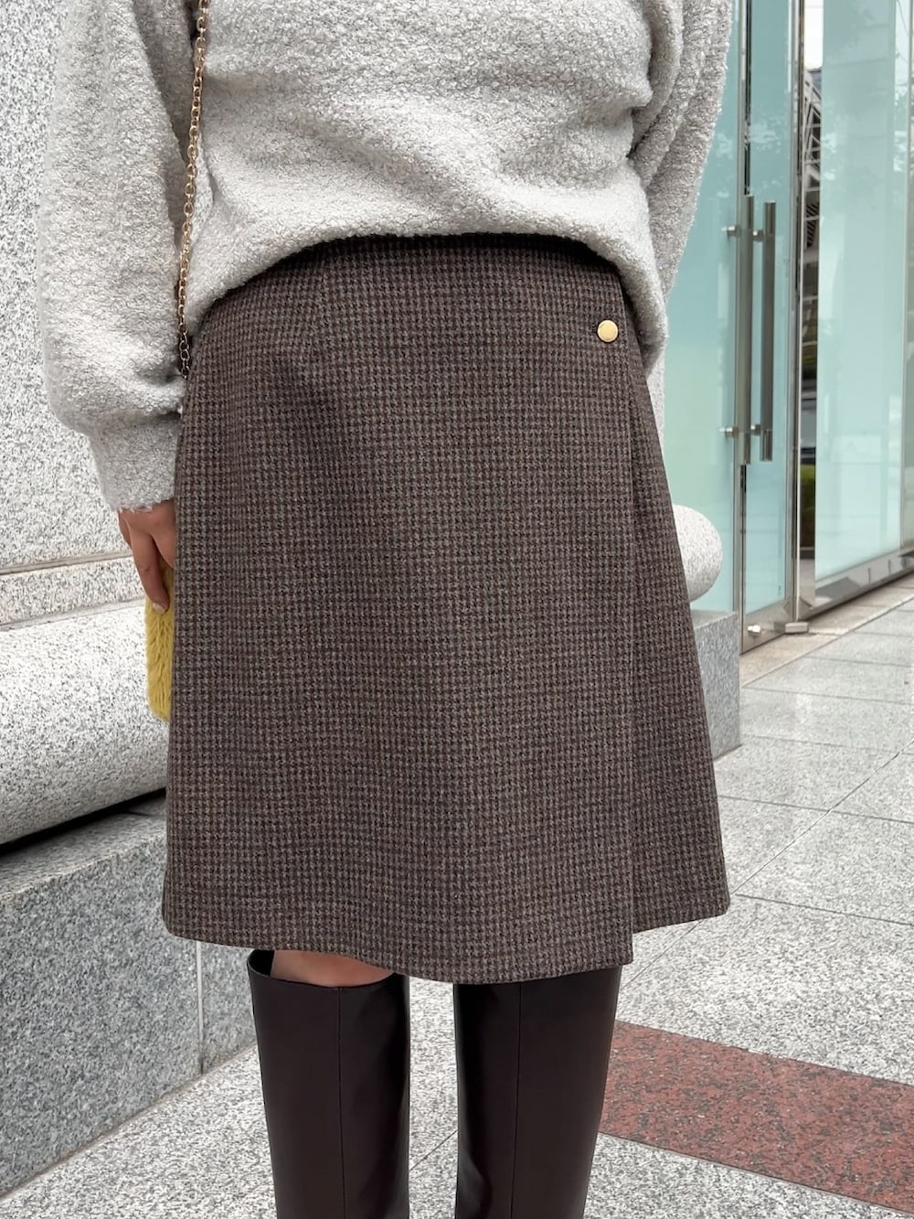 ブラウン系のブーツ、グレー系のニット/セーター、グレー系のスカートを着用したレディースの冬コーディネートの3枚目の写真