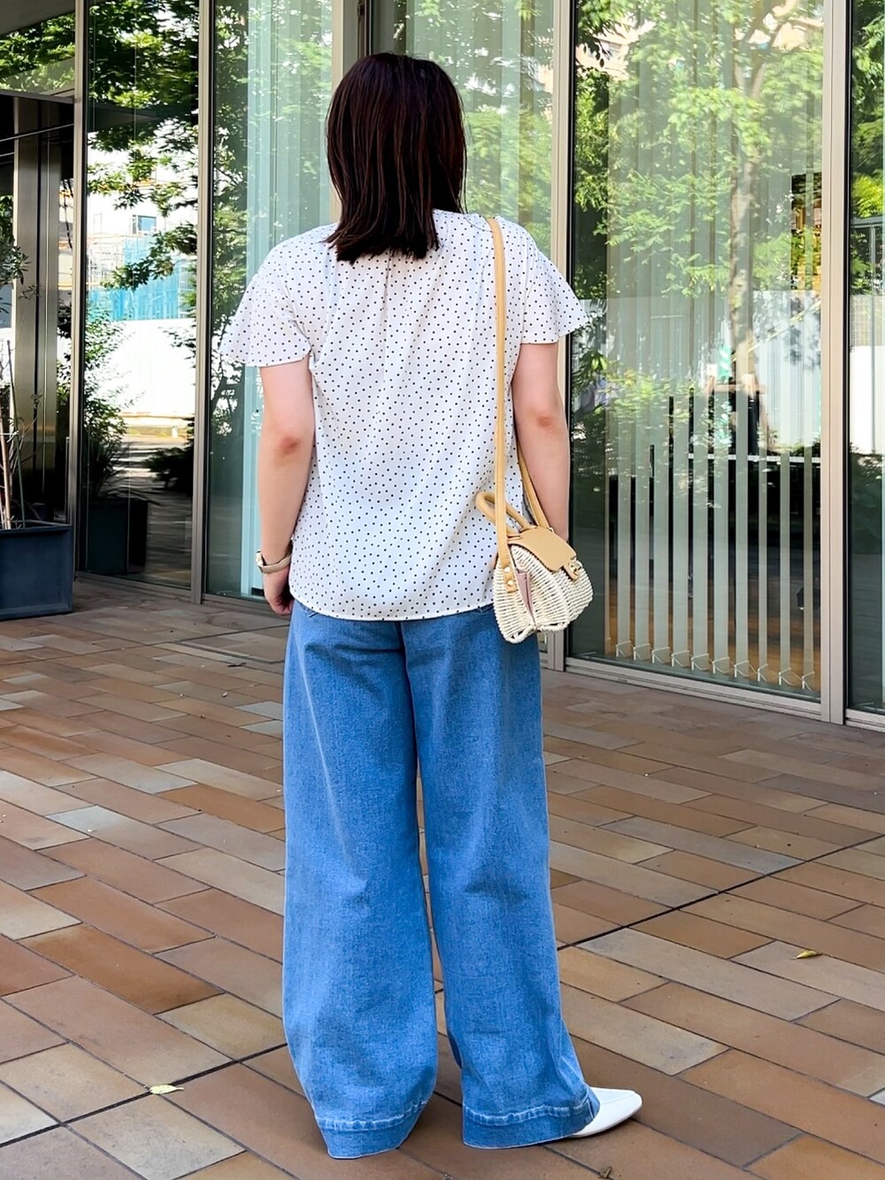 イエロー系のショルダーバッグ、ホワイト系のシャツ/ブラウス、ブルー系のデニムパンツを着用したレディースの春コーディネートの8枚目の写真