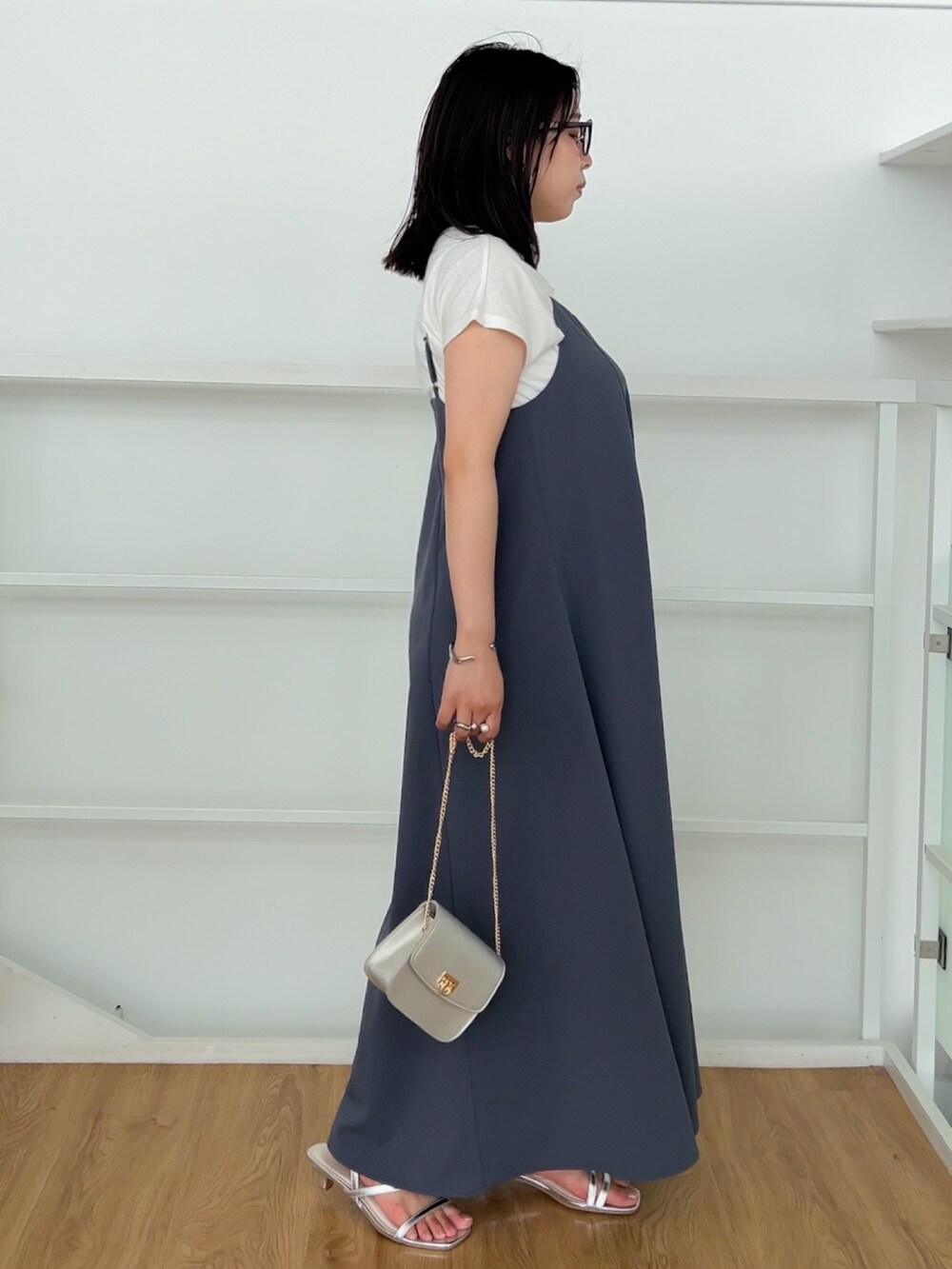 シルバー系のサンダル、シルバー系のショルダーバッグ、パープル系のワンピースを着用したレディースの夏コーディネートの2枚目の写真