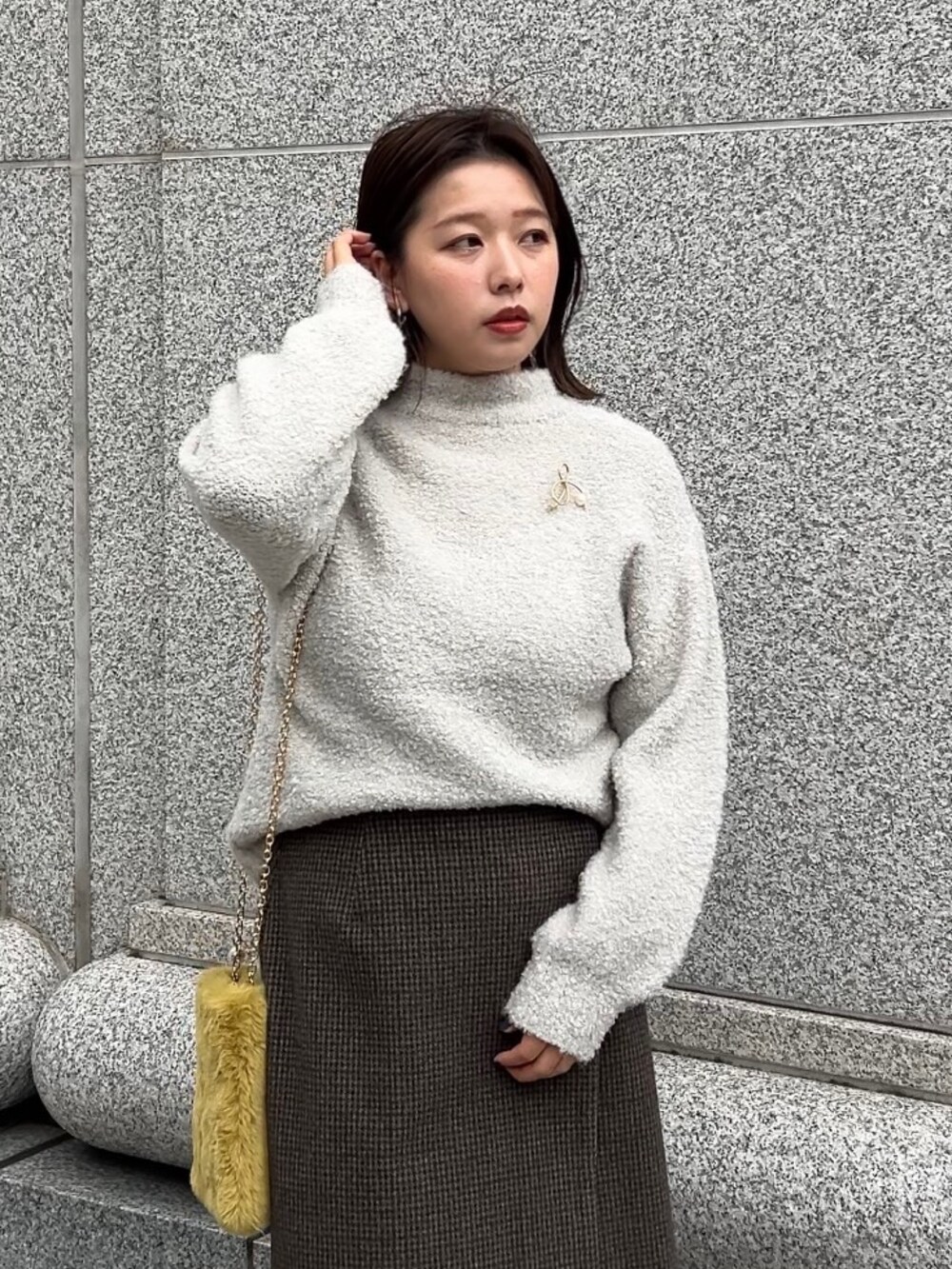 ブラウン系のブーツ、グレー系のニット/セーター、グレー系のスカートを着用したレディースの冬コーディネートの2枚目の写真