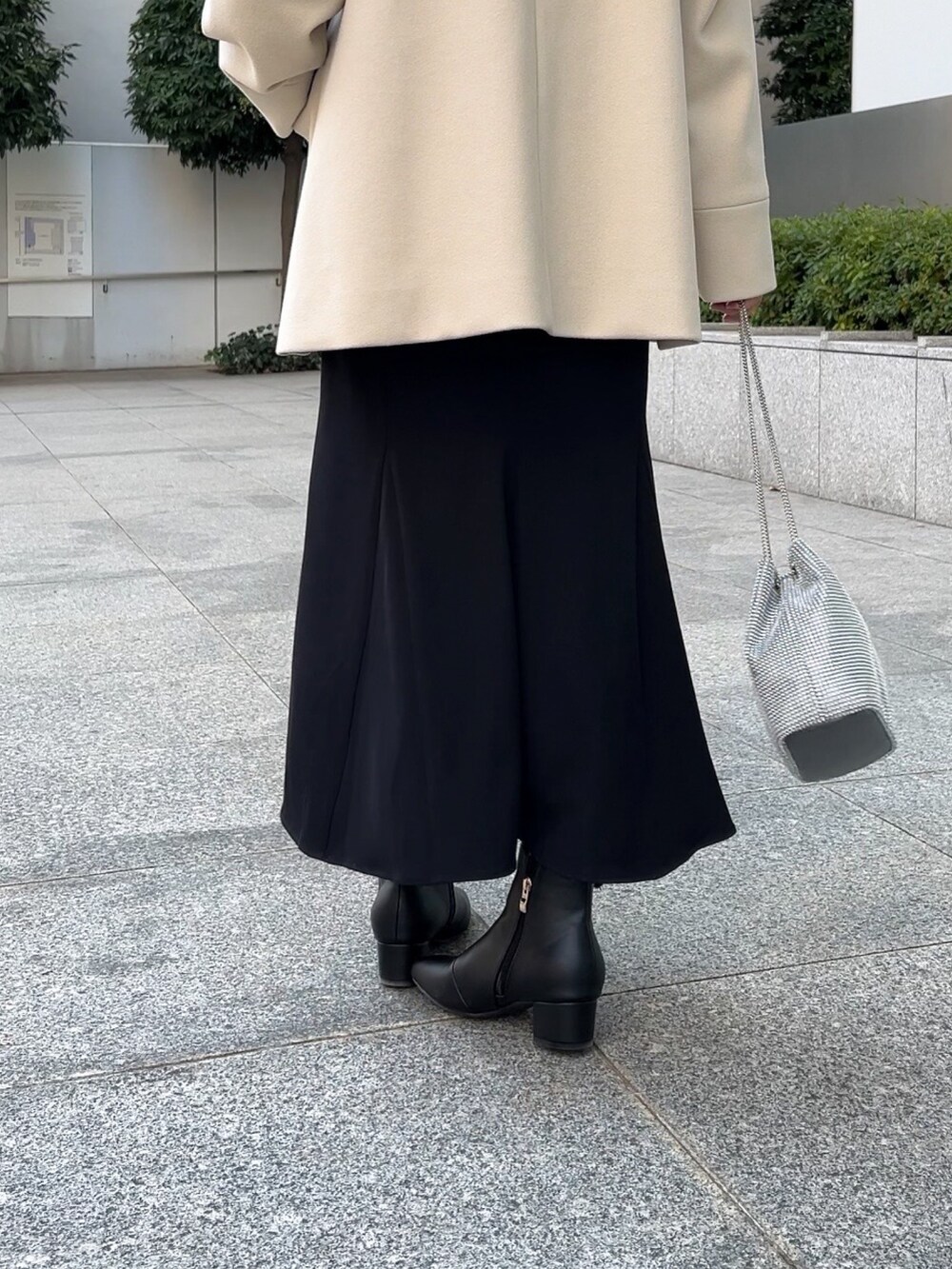 ベージュ系のその他アウター、レッド系のニット/セーター、ブラック系のスカートを着用したレディースの冬コーディネートの9枚目の写真