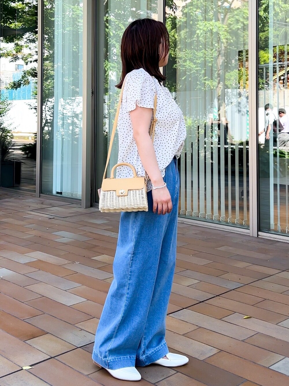 イエロー系のショルダーバッグ、ホワイト系のシャツ/ブラウス、ブルー系のデニムパンツを着用したレディースの春コーディネートの7枚目の写真