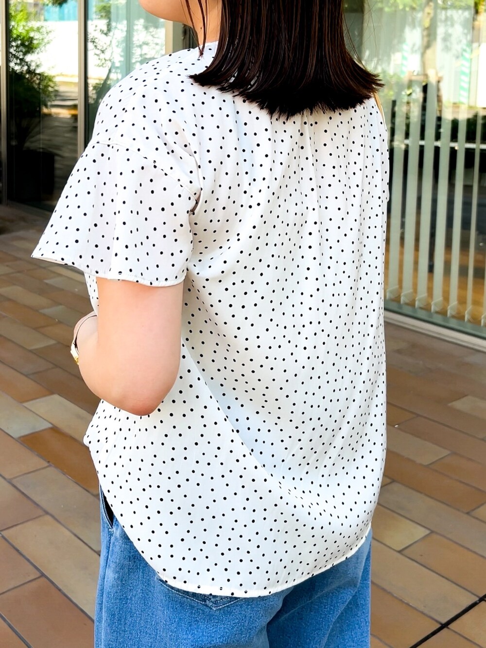 イエロー系のショルダーバッグ、ホワイト系のシャツ/ブラウス、ブルー系のデニムパンツを着用したレディースの春コーディネートの4枚目の写真