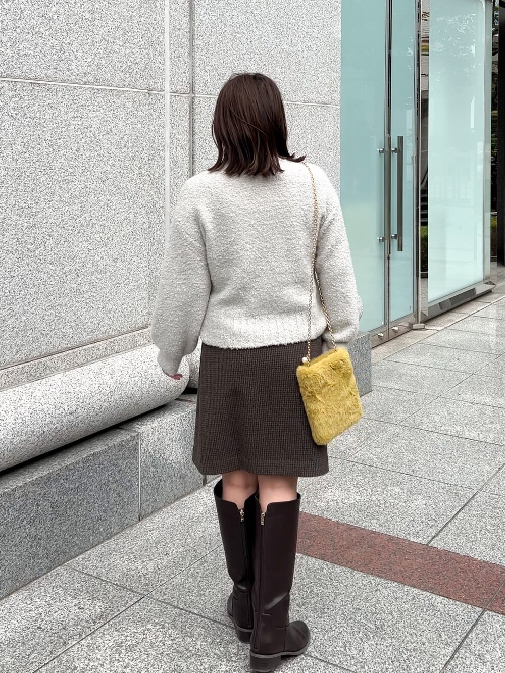 ブラウン系のブーツ、グレー系のニット/セーター、グレー系のスカートを着用したレディースの冬コーディネートの7枚目の写真