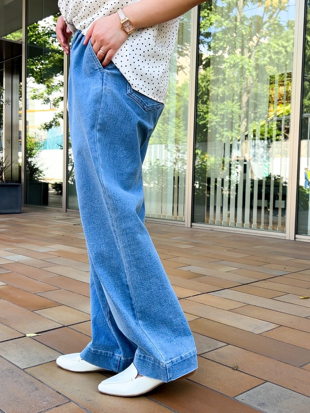 イエロー系のショルダーバッグ、ホワイト系のシャツ/ブラウス、ブルー系のデニムパンツを着用したレディースの春コーディネートの6枚目の写真