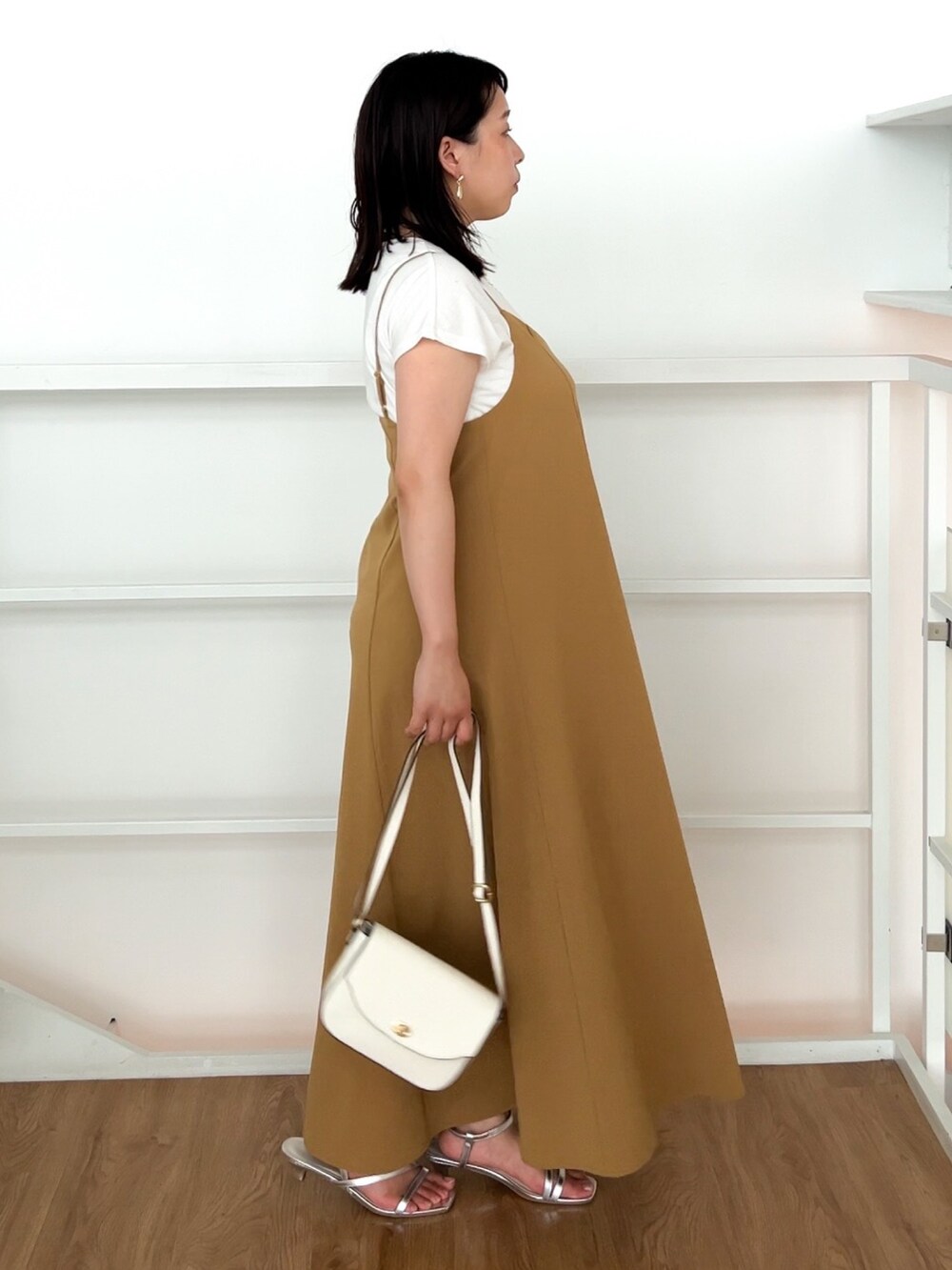 イエロー系のワンピース、ホワイト系のショルダーバッグ、シルバー系のサンダルを着用したレディースの夏コーディネートの4枚目の写真