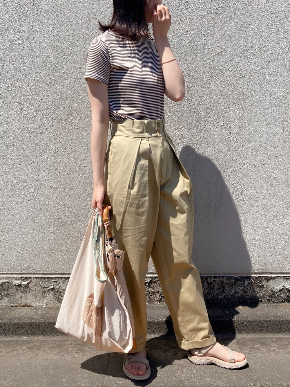 ブラウン系のTシャツ/カットソー、ベージュ系のエコバッグ/サブバッグ、ベージュ系のサンダルを着用したレディースの夏コーディネートの2枚目の写真