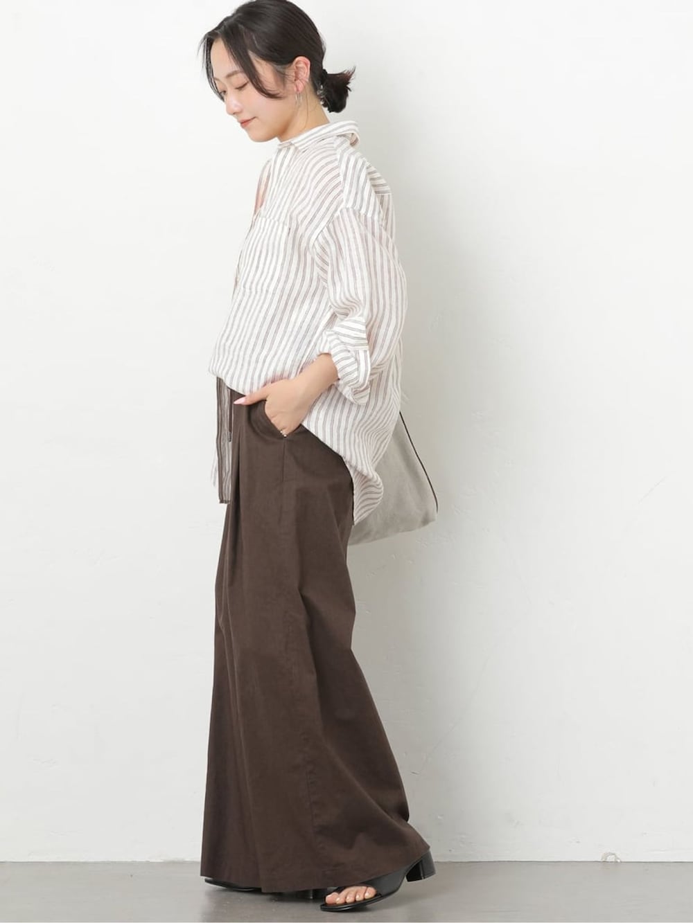 ブラウン系のその他パンツ、ブラウン系のシャツ/ブラウス、ブラック系のサンダルを着用したレディースの春コーディネートの2枚目の写真