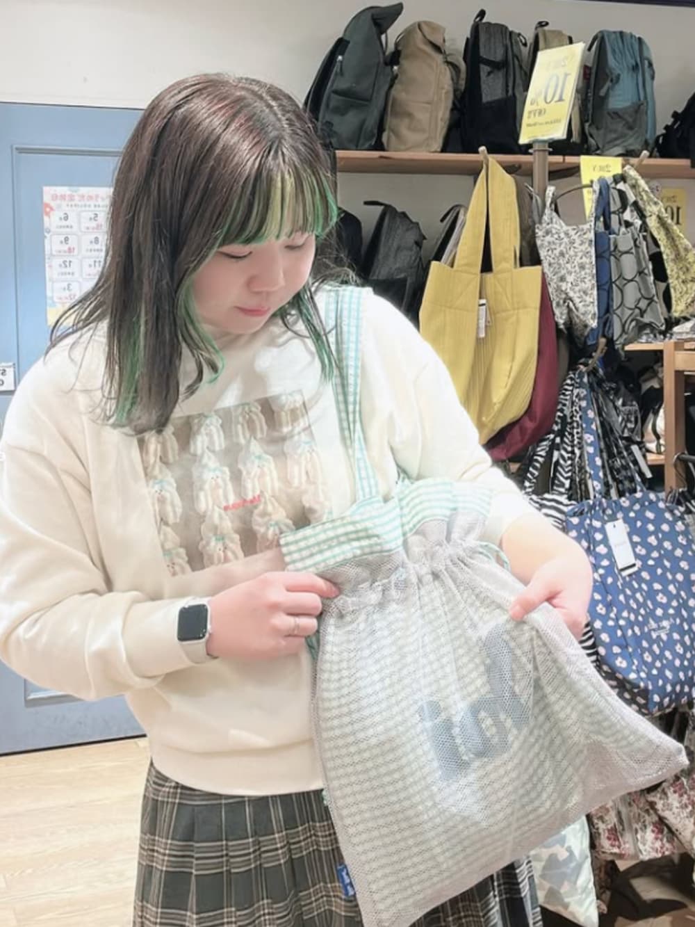 グリーン系のトートバッグを着用したレディースの冬コーディネートの2枚目の写真