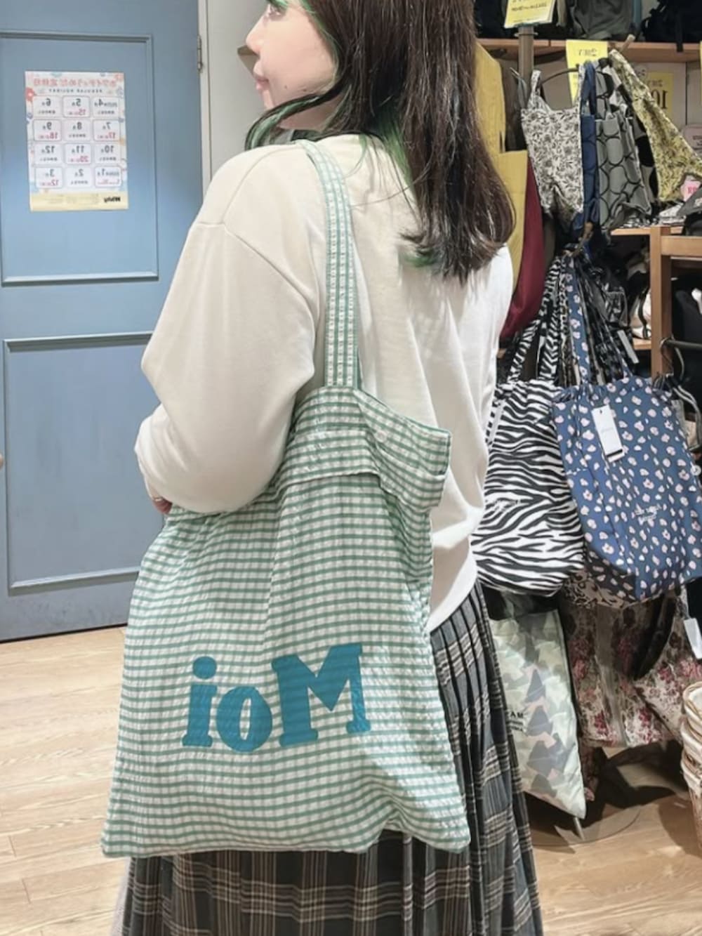 グリーン系のトートバッグを着用したレディースの冬コーディネートの3枚目の写真