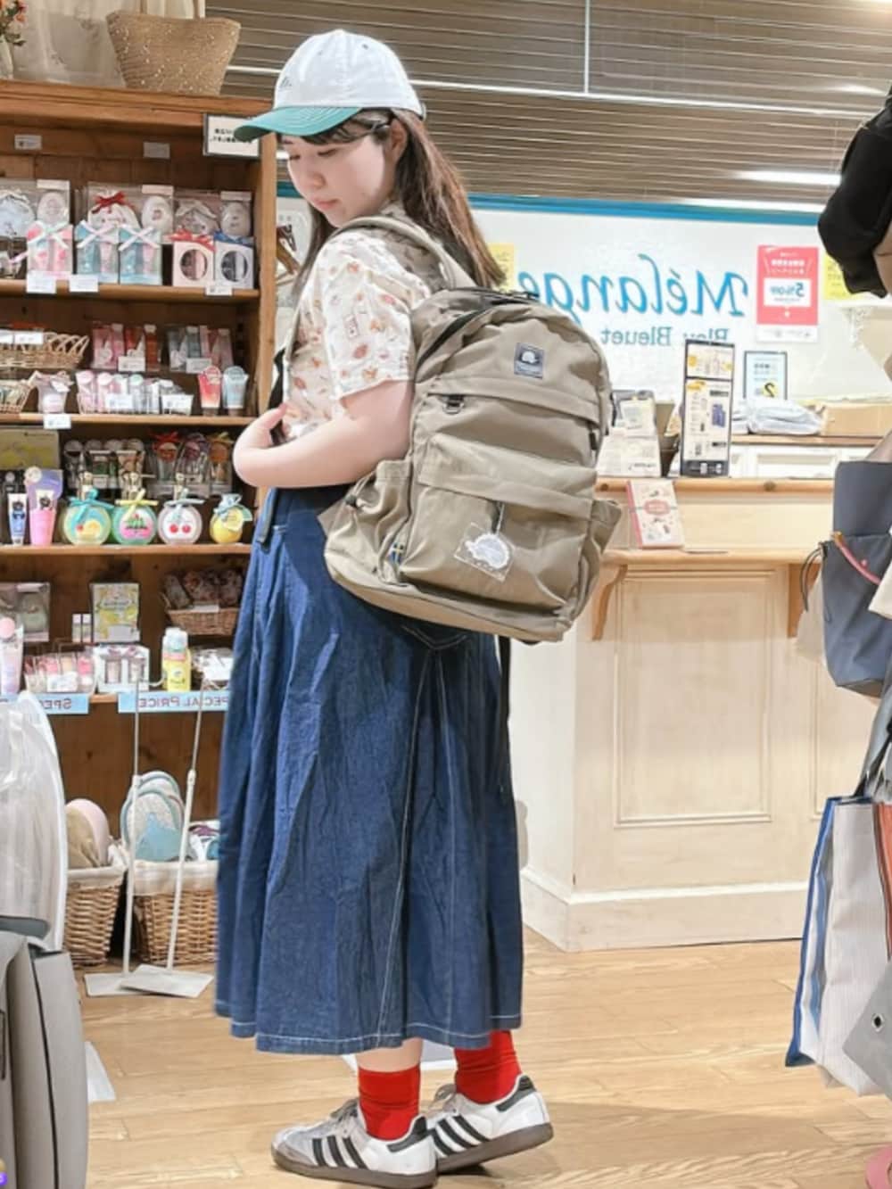 その他のシャツ/ブラウス、ベージュ系のバックパック/リュック、グリーン系のキャップを着用したレディースの夏コーディネートの2枚目の写真