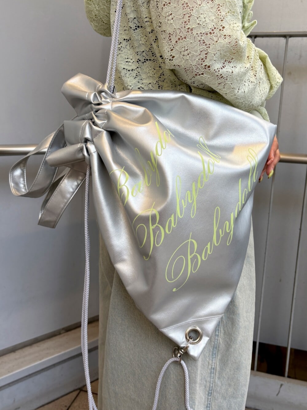 グリーン系のパーカー、ブラック系のキャミソール、ブルー系のデニムパンツを着用したレディースの春コーディネートの8枚目の写真