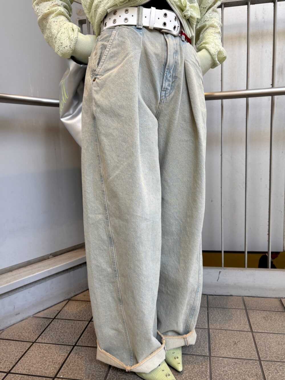 グリーン系のパーカー、ブラック系のキャミソール、ブルー系のデニムパンツを着用したレディースの春コーディネートの9枚目の写真