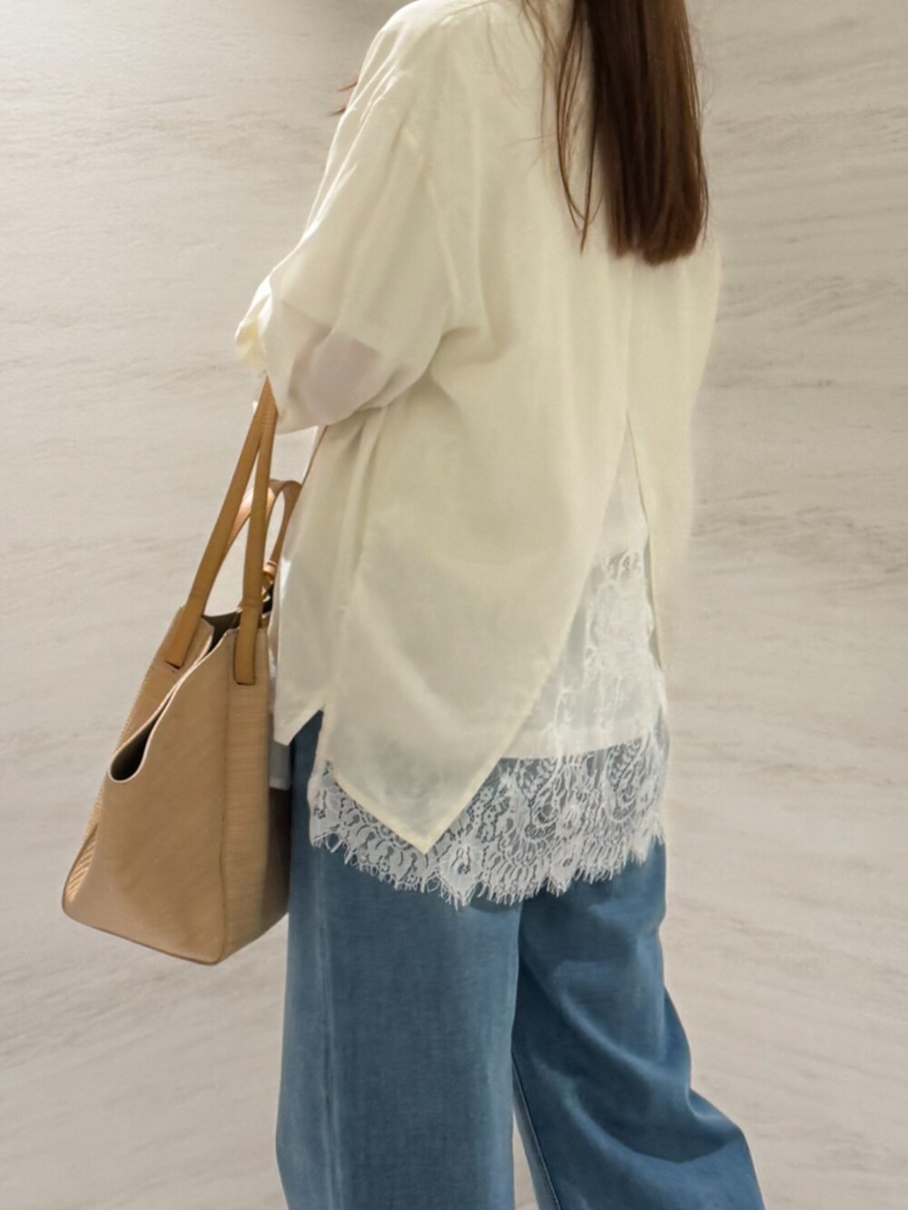 ベージュ系のトートバッグ、ブルー系のデニムパンツ、ホワイト系のシャツ/ブラウスを着用したレディースの夏コーディネートの4枚目の写真